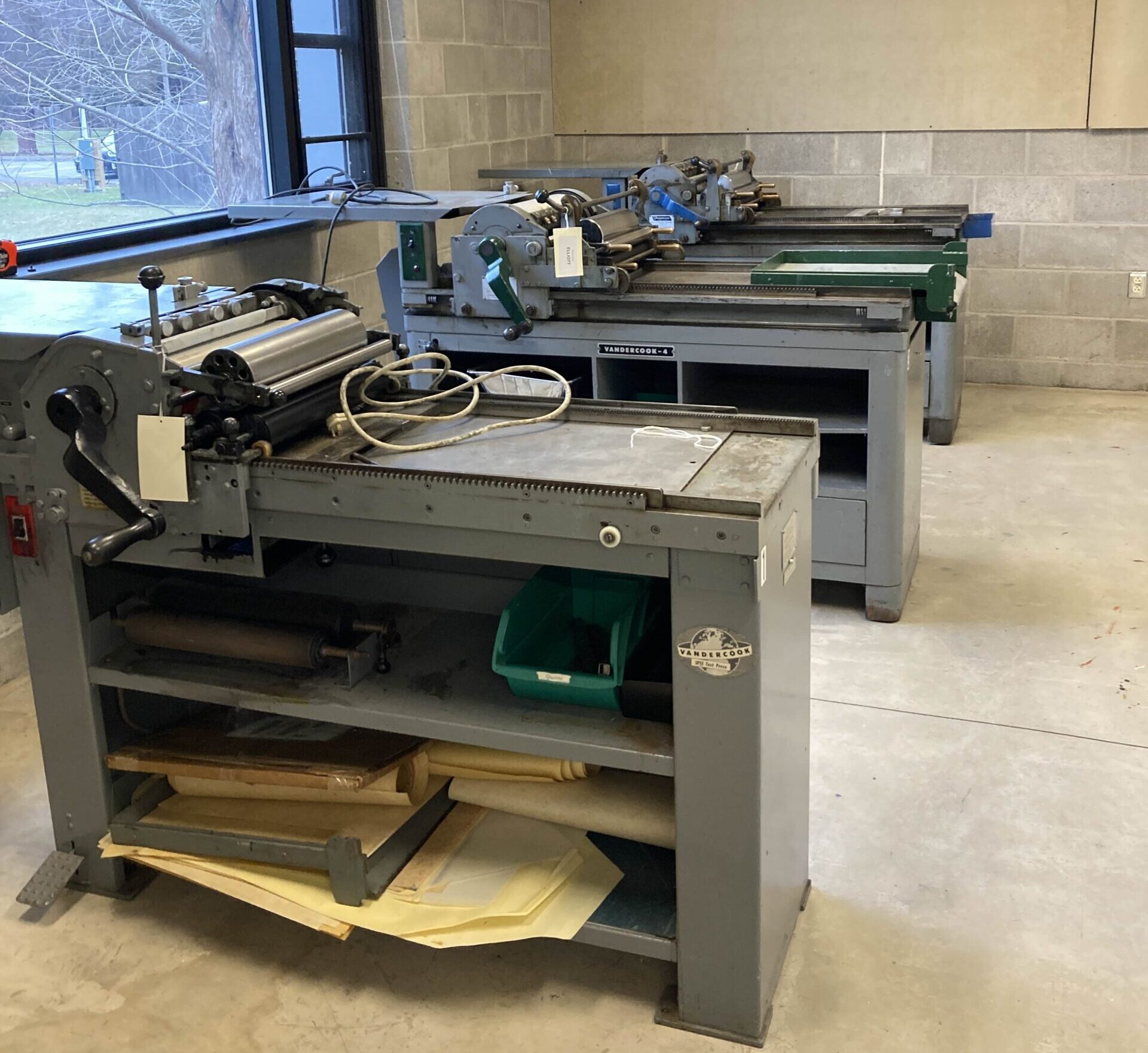 Image of 3 Vandercook presses in a row in a room, with window visible above, showing the new WBAC classroom space at HWS